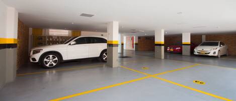 Un parking où sont garées des voitures blanches et rouges, chacune occupant une place désignée.