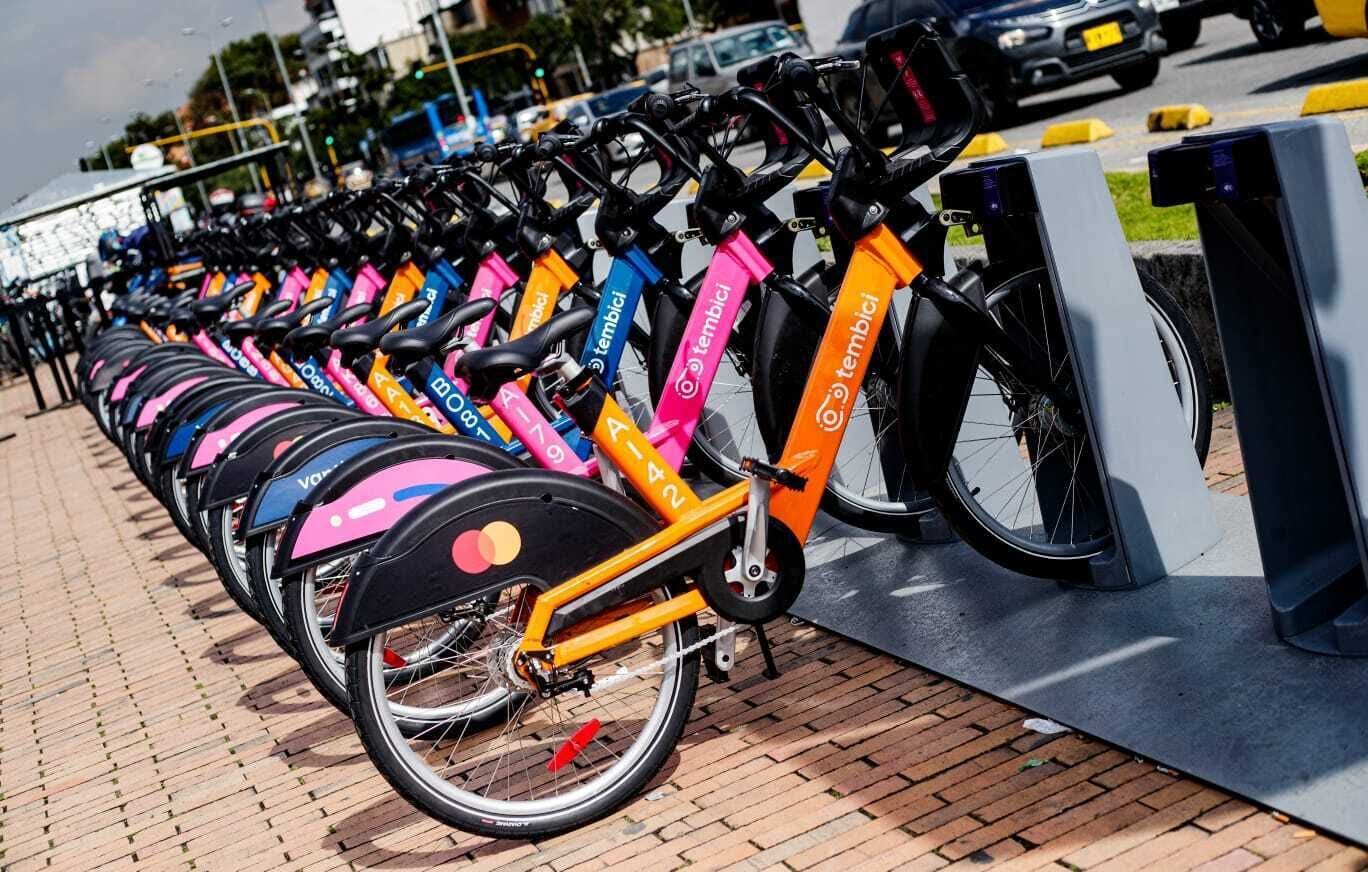 Una fila di biciclette colorate parcheggiate a una stazione.