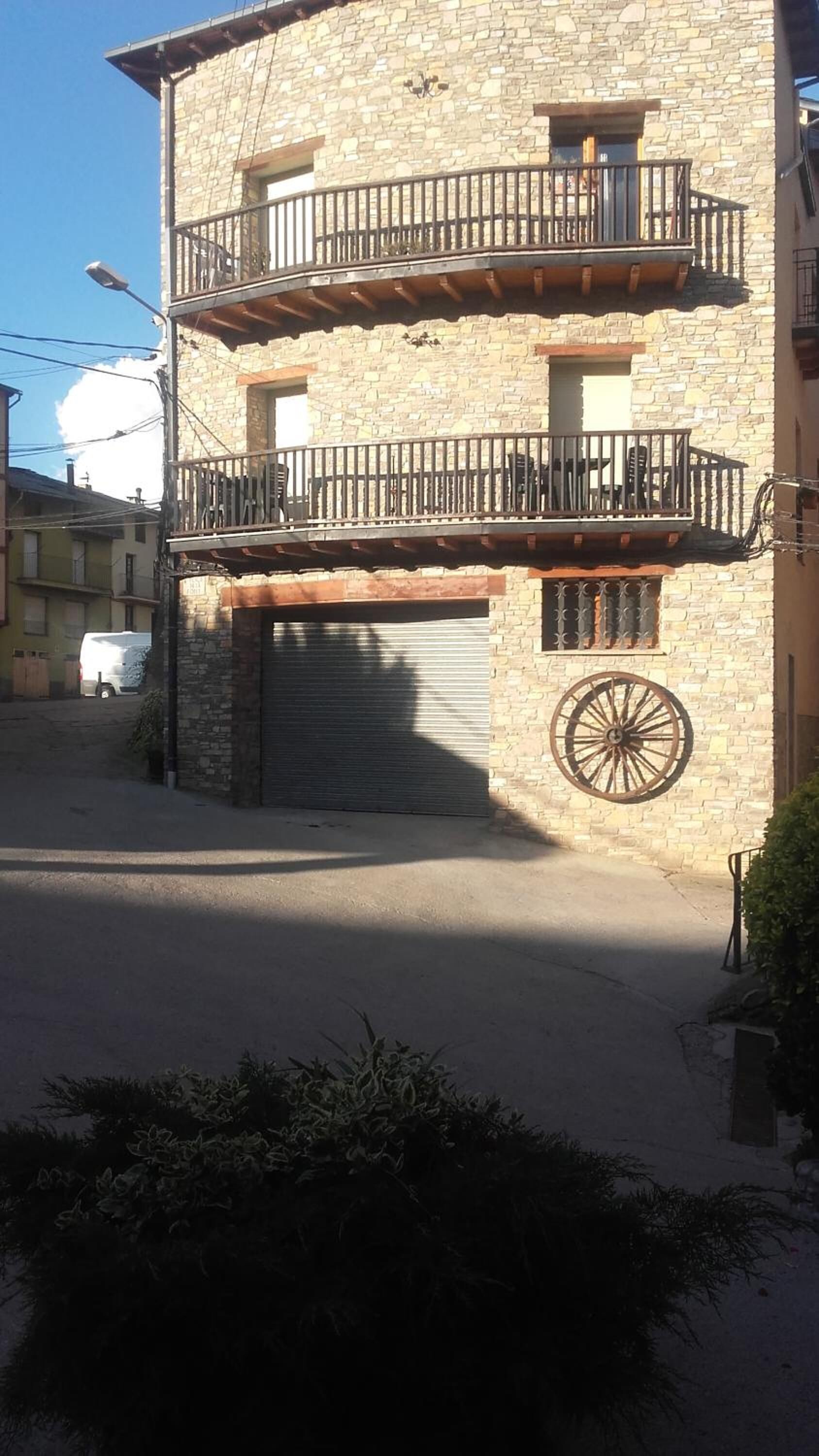 A two-story stone building with a balcony on the upper floor.