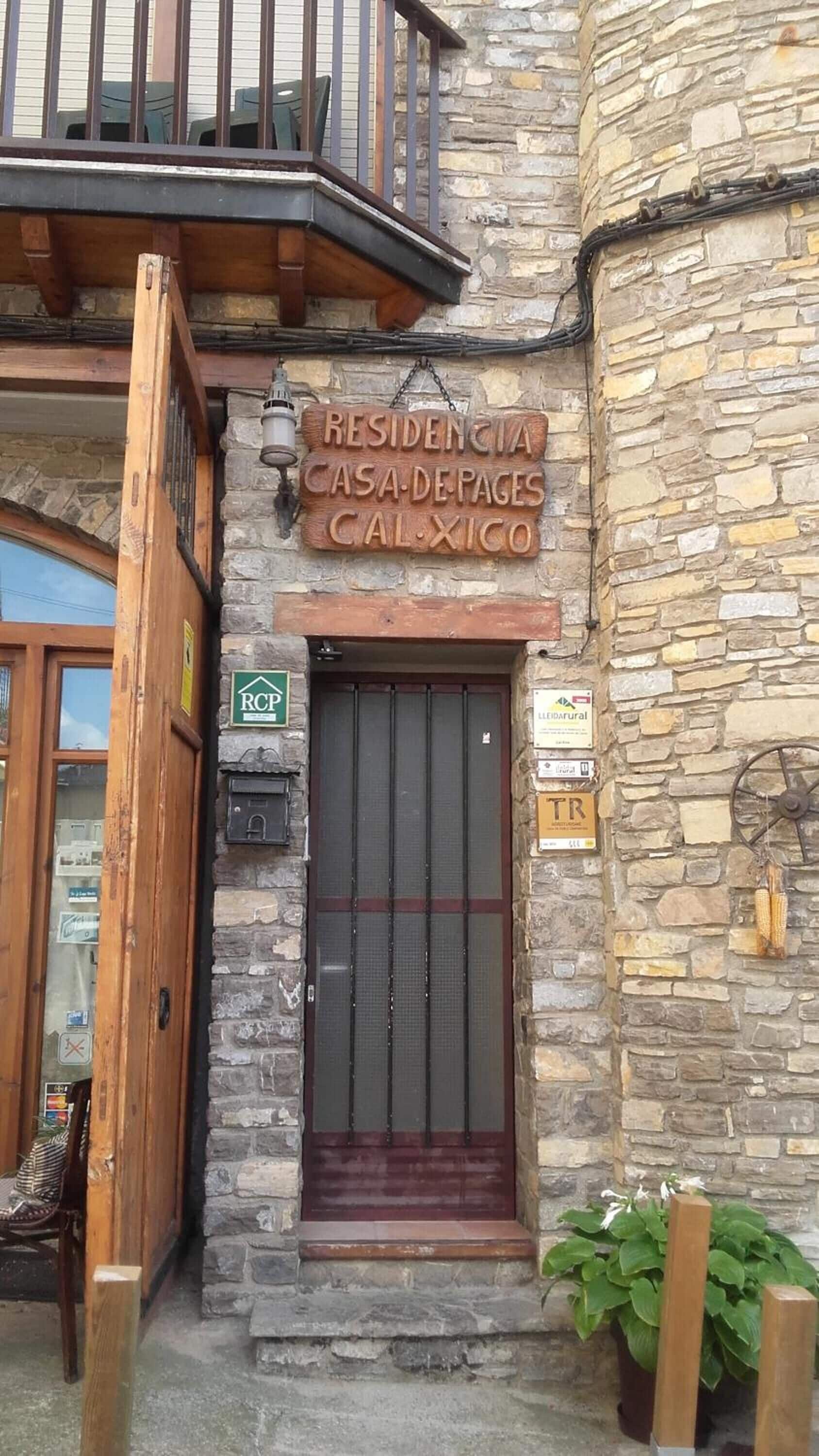 A stone building with a wooden door and a balcony.
