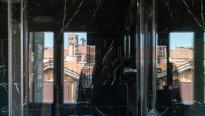 A reflection of buildings in a glass window with a marble pattern. - Palazzo San Luca (Venice)