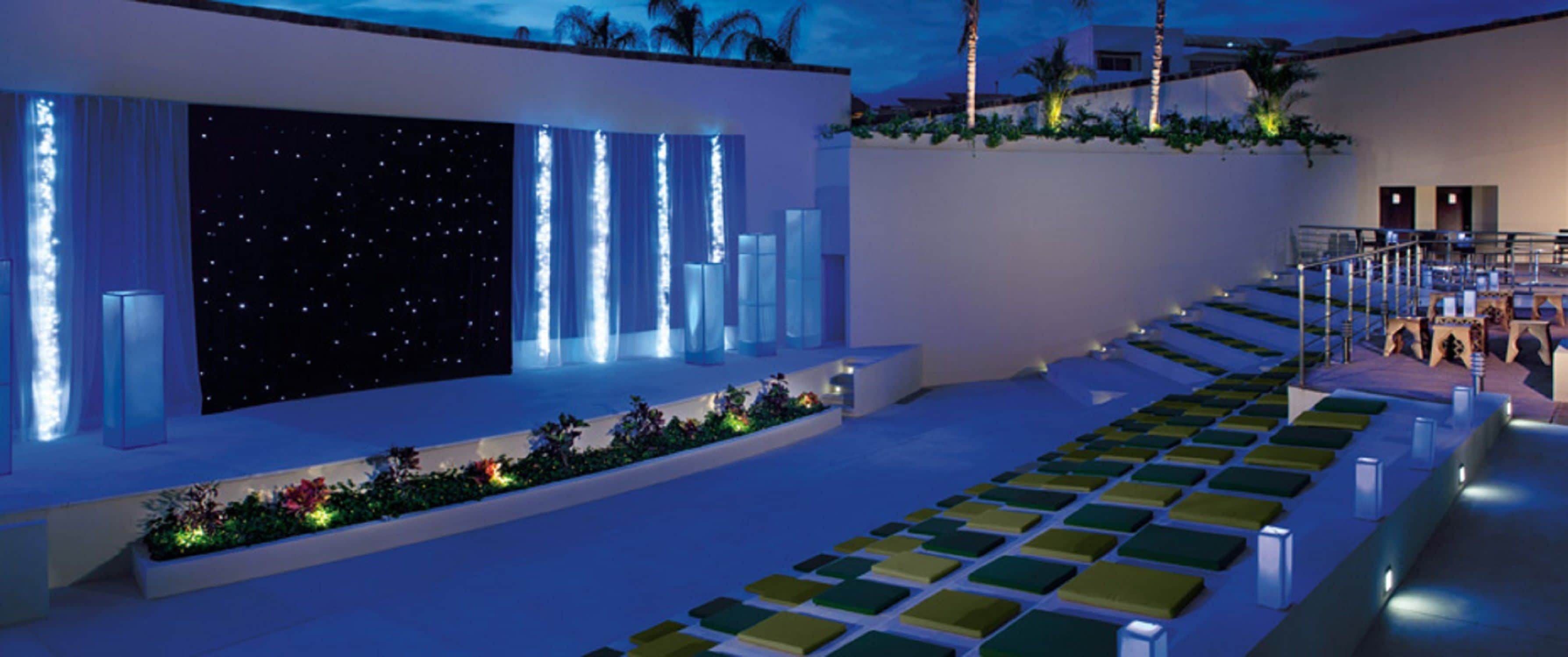 A modern outdoor area with a seating arrangement and a decorative wall with vertical lights.