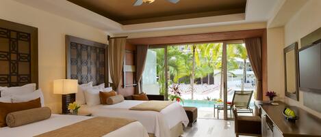 A hotel room with two beds, a ceiling fan, a desk with a TV, and a view of a pool area.
