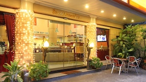 Exterior del Silom Avenue Inn, con un centro de masajes, zona de estar al aire libre y plantas decorativas.