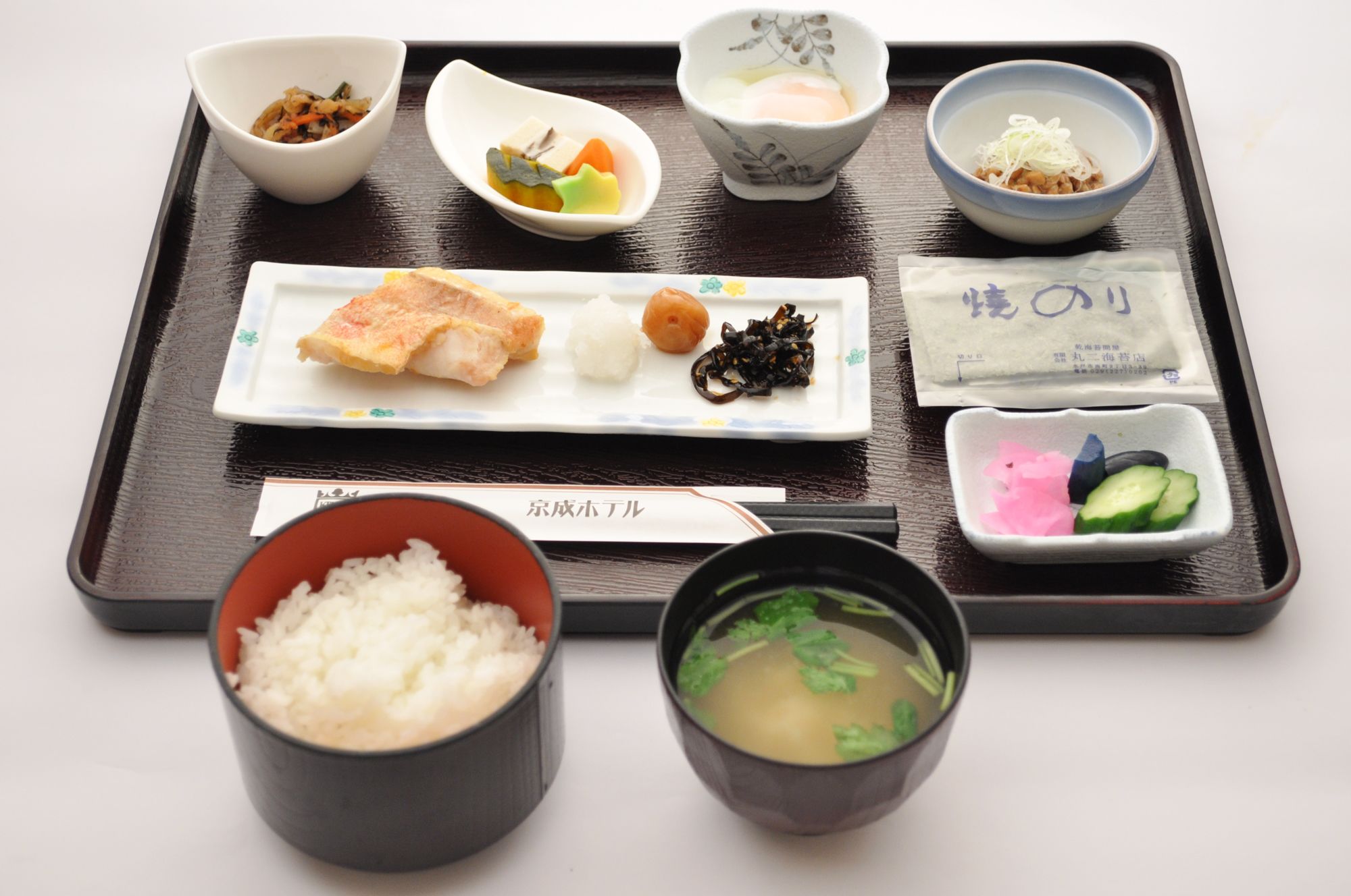 A tray with various Japanese dishes including sushi, rice, and soup.