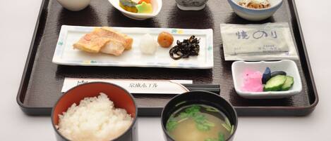 A tray with various Japanese dishes including sushi, rice, and soup.