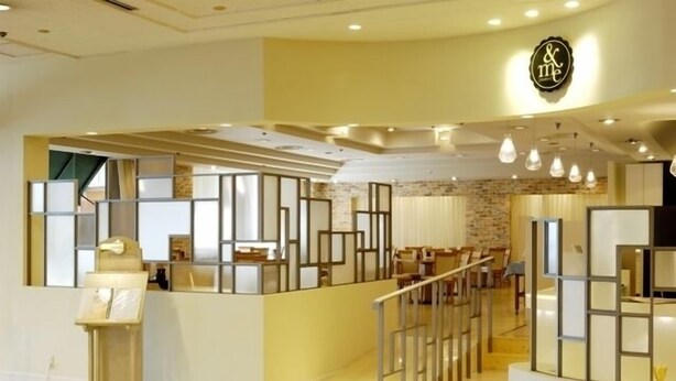 A modern hotel lobby with a reception desk, seating area, and a staircase. - Mito Keisei Hotel (Mito)