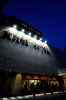 Exterior de un hotel de noche con señalización iluminada.