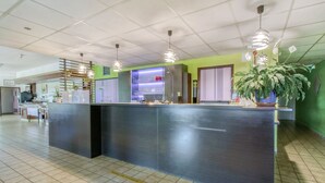 A reception area with a counter, a bar, and a seating area. - Brit Hotel Confort Pau Lons (Lons)