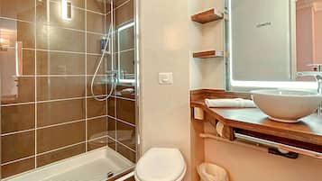 A bathroom with a shower, toilet, and sink.
