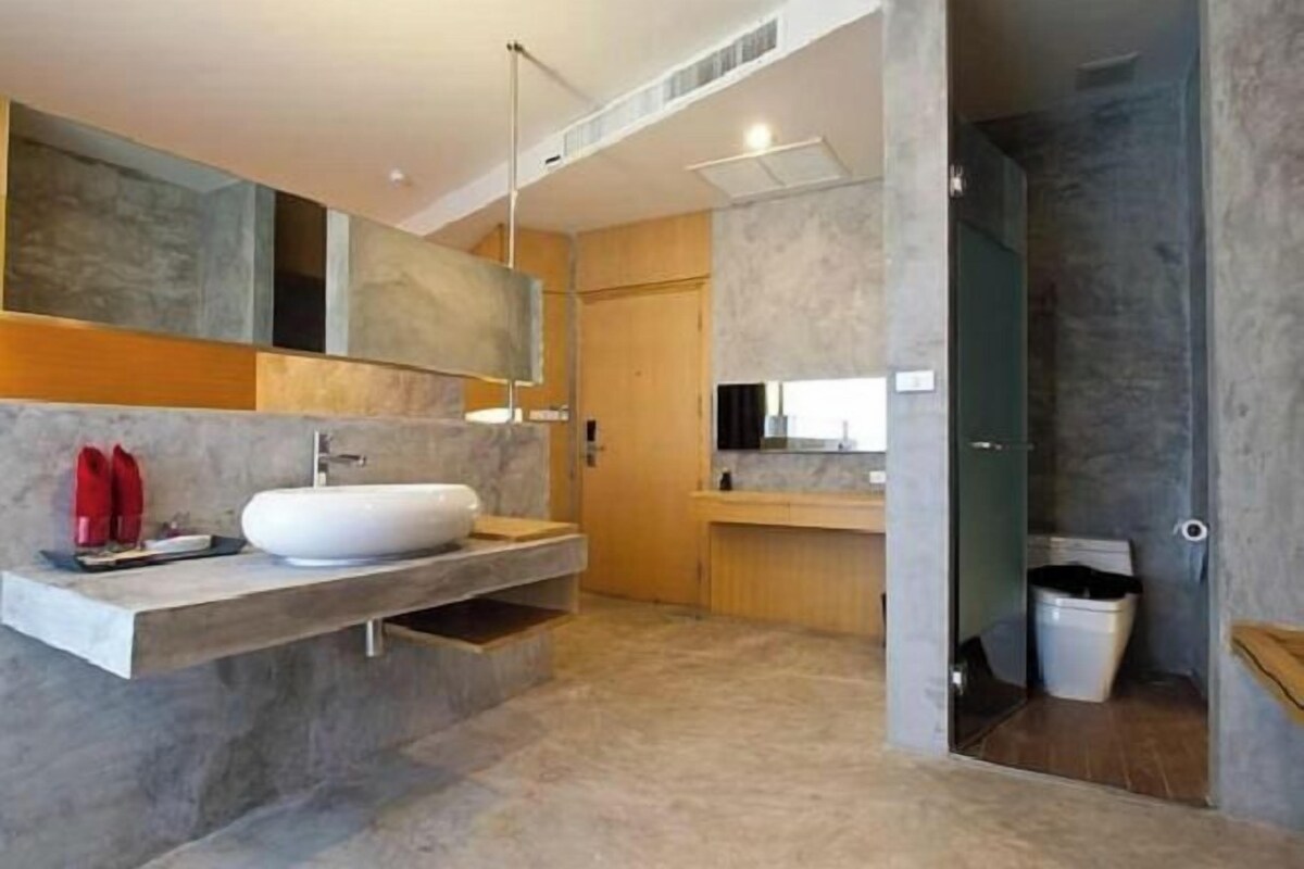 A modern bathroom with a large mirror, a built-in sink, and a shower area.