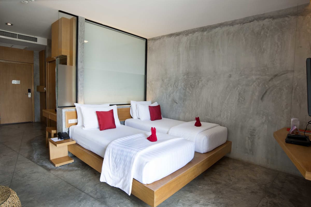 A modern hotel room with a large bed, a desk, and a television.