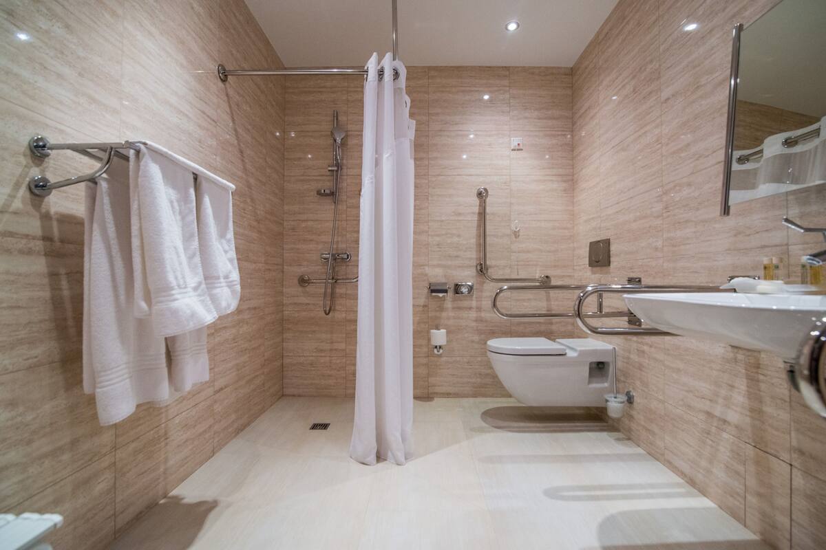 Un baño moderno con ducha, inodoro y lavamanos.
