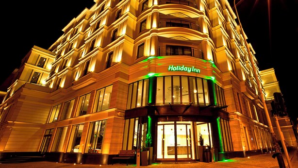 A multi-story Holiday Inn hotel with a prominent entrance and illuminated signage.