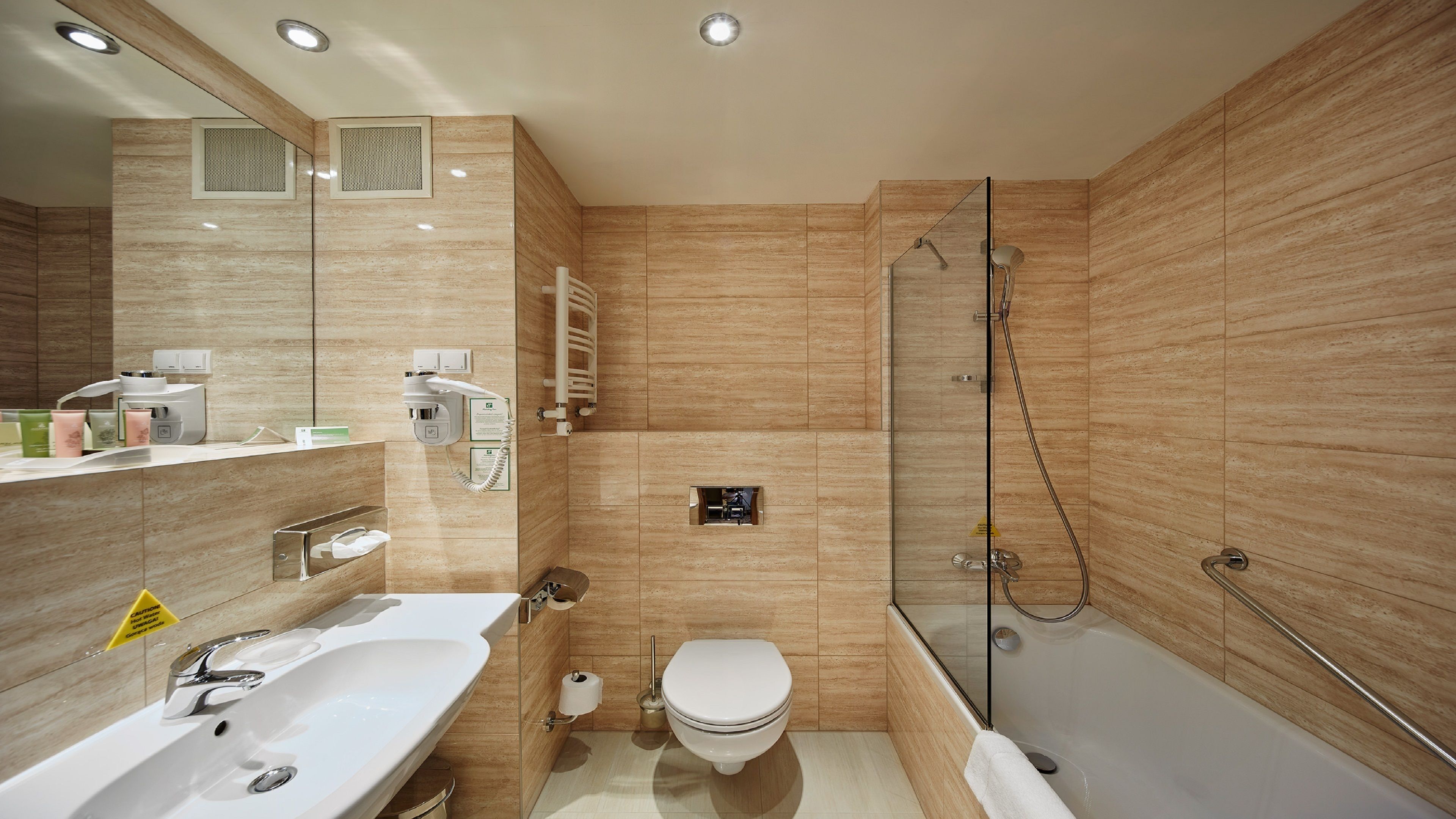 A modern bathroom with a large sink, toilet, and walk-in shower.