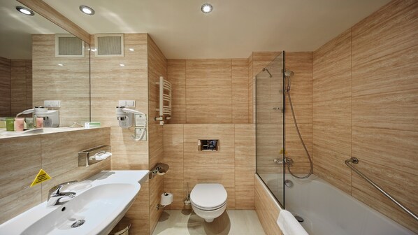 Un baño moderno con un lavamanos grande, inodoro y ducha a ras de suelo.