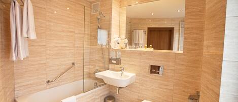 A modern bathroom with a bathtub, sink, and toilet.