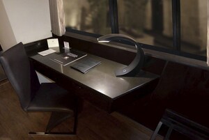 Un escritorio moderno con una silla, una computadora portátil y un teléfono inteligente.