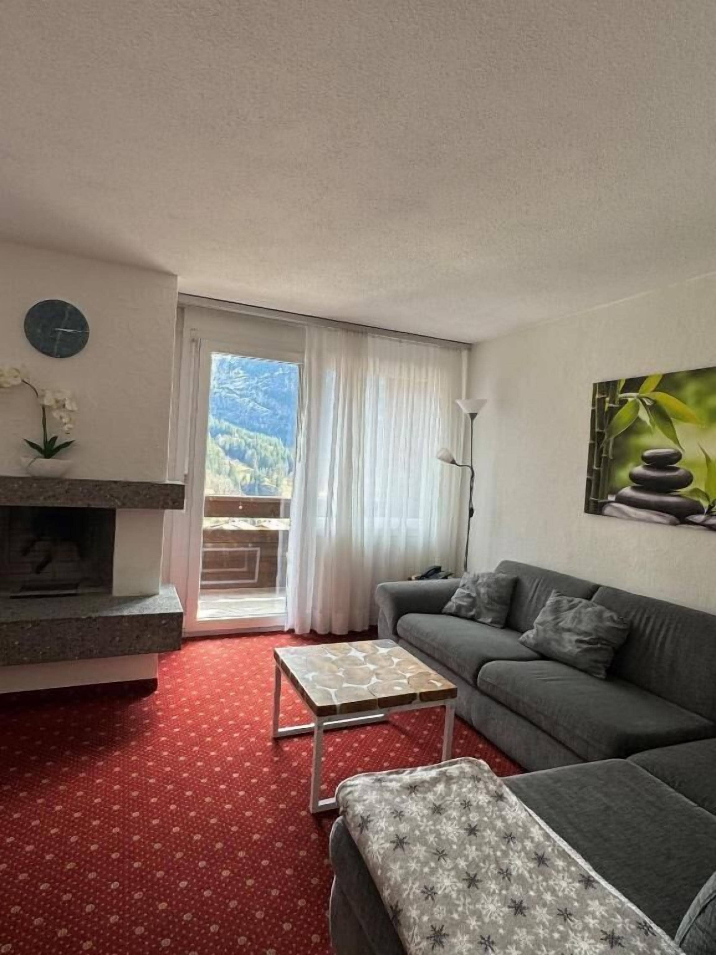 Una sala de estar con sofá, mesa de centro, chimenea y un cuadro.