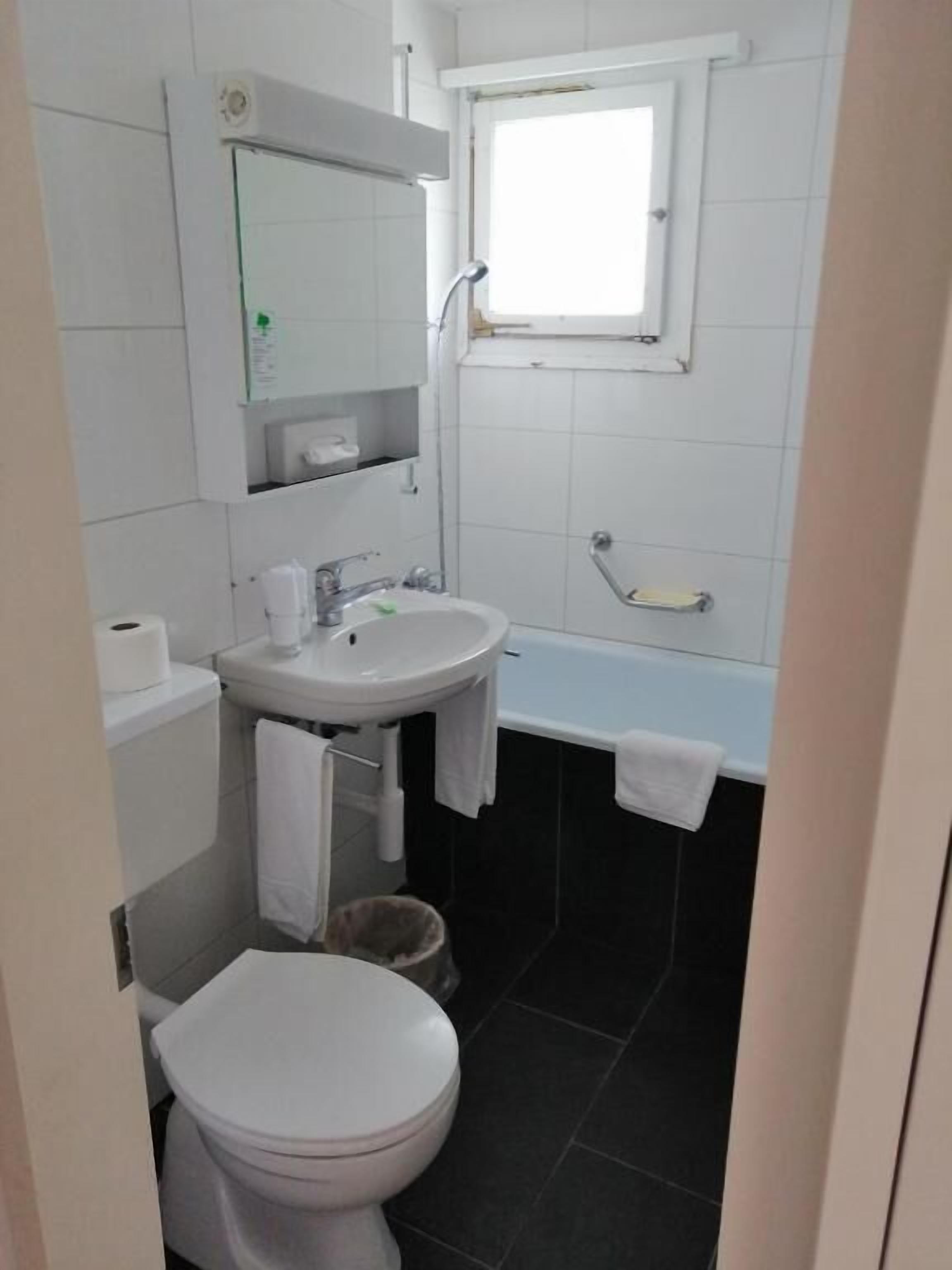 Ein kleines Badezimmer mit Toilette, Waschbecken und Badewanne.