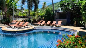 Un espace piscine équipé de chaises longues et d’un panneau indiquant « Complexe hôtelier ».