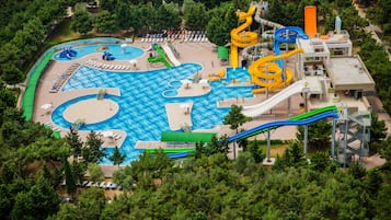 Enjoy water slides, pools, and a beach area amidst lush surroundings.