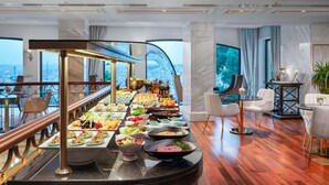 A buffet setup with various food items, a bar area, and a view of the city. - Rixos Pera Istanbul - Nickelodeon Play Access (Istanbul)