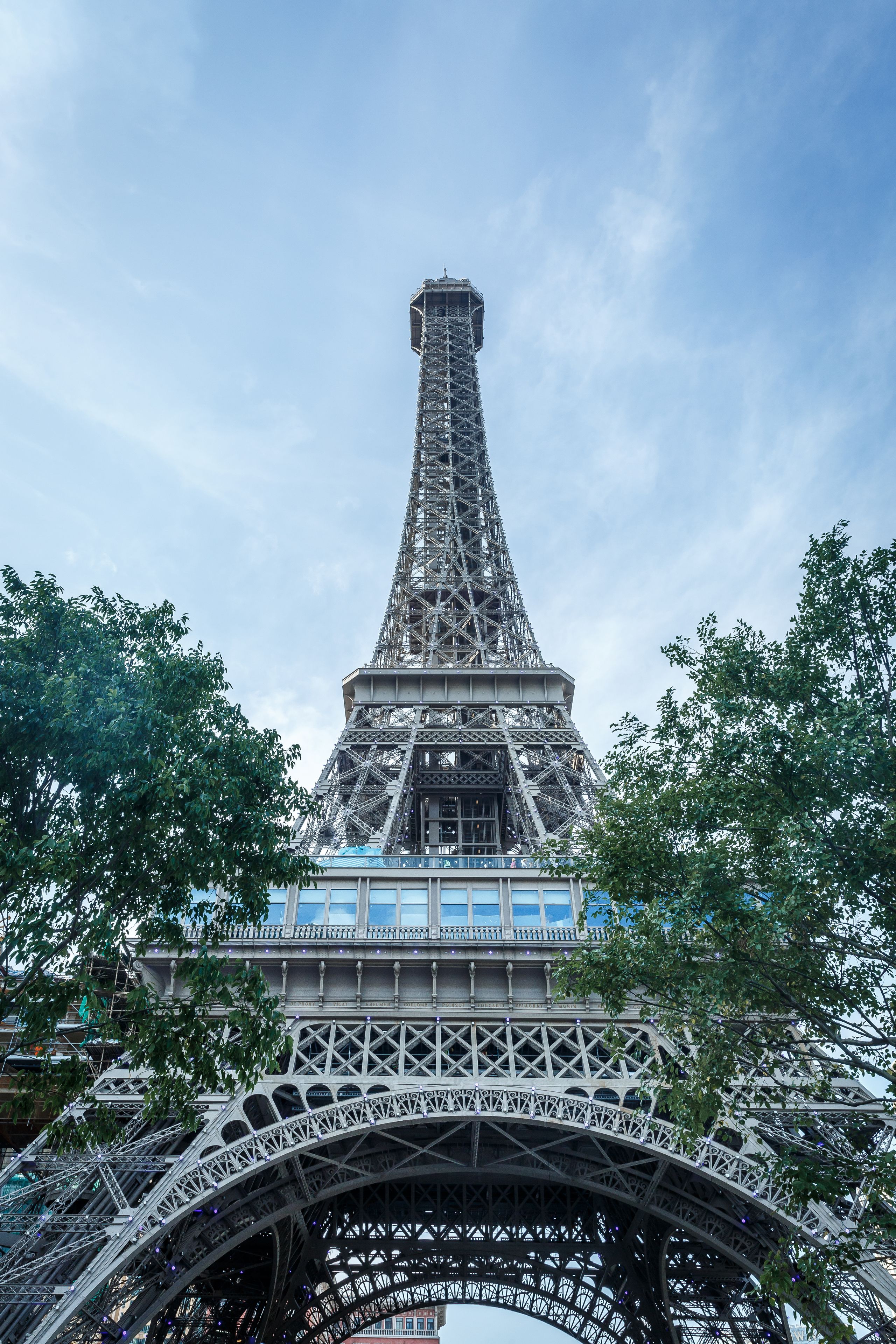 The Eiffel Tower with a view of the surrounding area, including trees and a bridge.