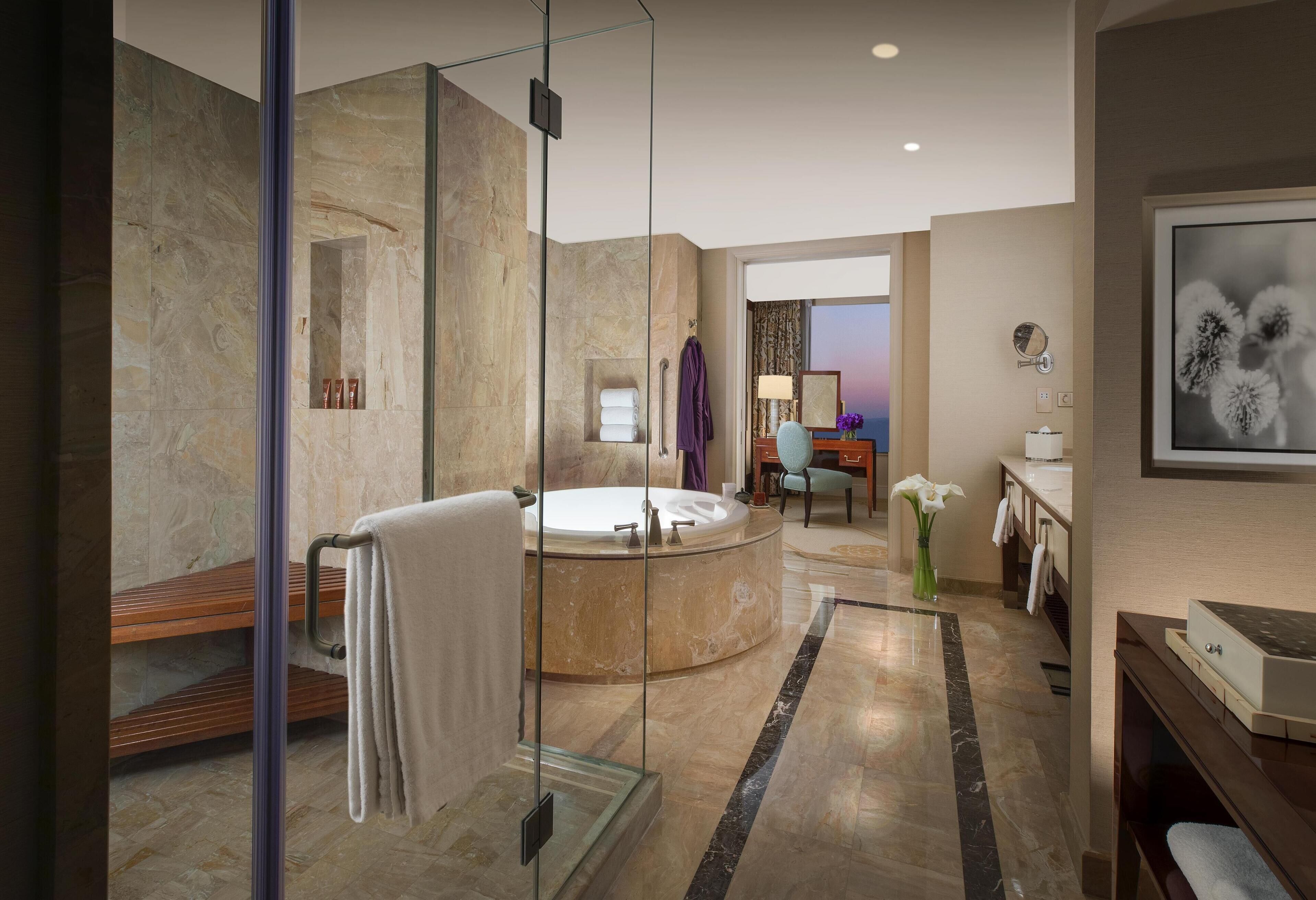 A modern bathroom with a glass-enclosed shower, a freestanding bathtub, and a vanity with a mirror.