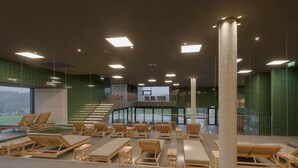 A spacious indoor swimming pool area with multiple sun loungers and a staircase leading to an upper level. - Loisium Wine & Spa Hotel Südsteiermark  (Ehrenhausen an der Weinstraße)