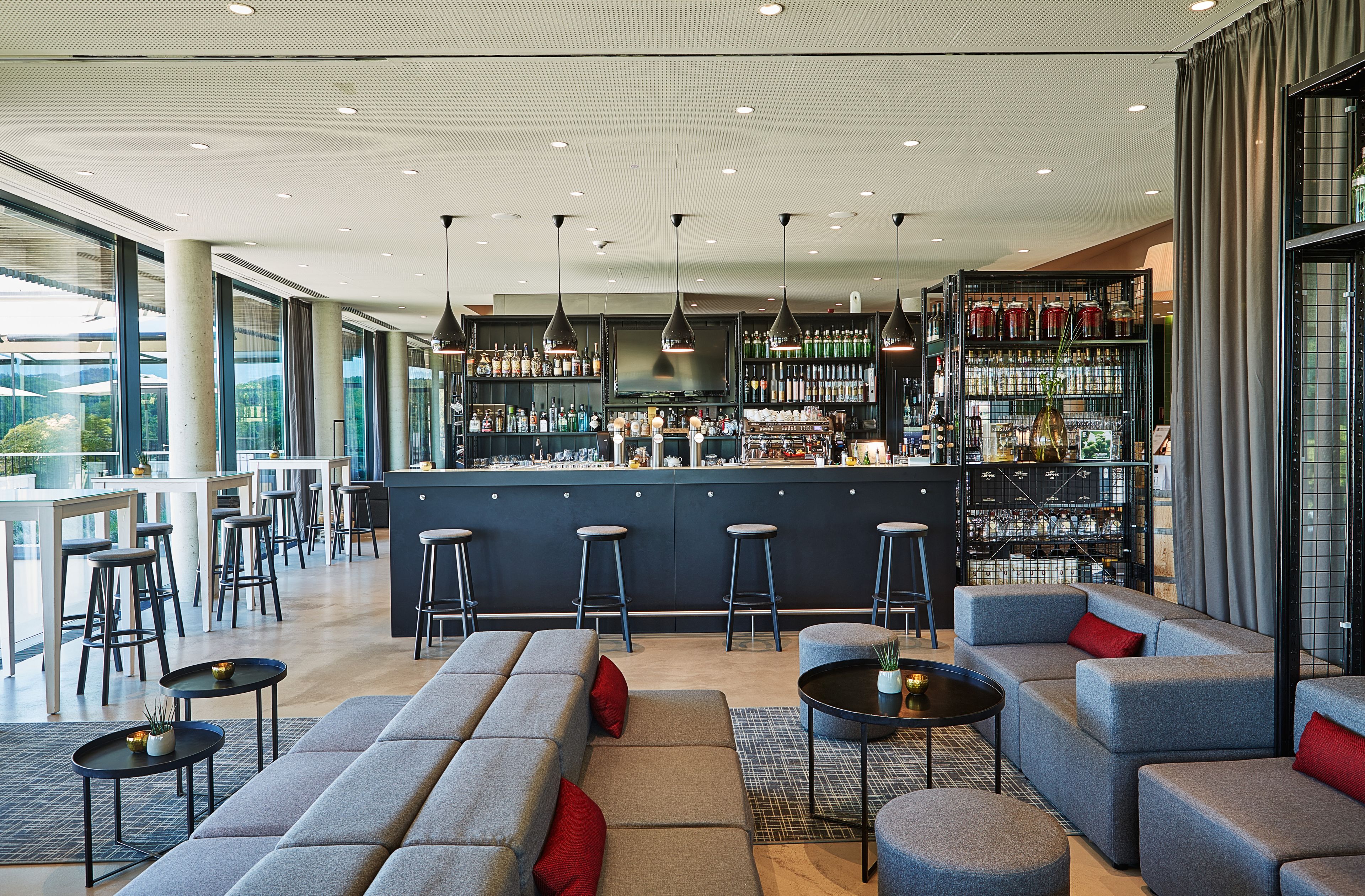 Zona bar moderna con posti a sedere e bancone.