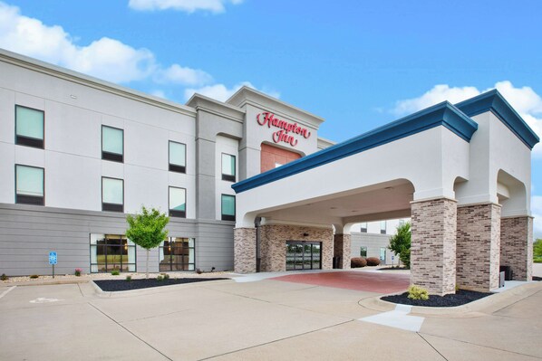 A Hampton Inn hotel with a modern facade, a covered entrance, and a landscaped driveway.