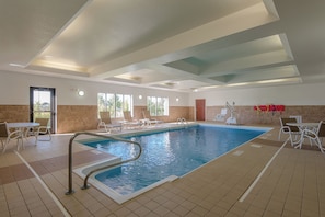 An indoor swimming pool with clear water, surrounded by lounge chairs and a tiled floor. - Holiday Inn Express & Suites Lafayette East by IHG (Lafayette)