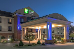 Ein Holiday Inn Express & Suites Hotel mit überdachter Zufahrt und einer Ziegel-Fassade.