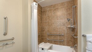A bathroom with a bathtub, shower, and handrails. - Holiday Inn Express & Suites Lafayette East by IHG (Lafayette)