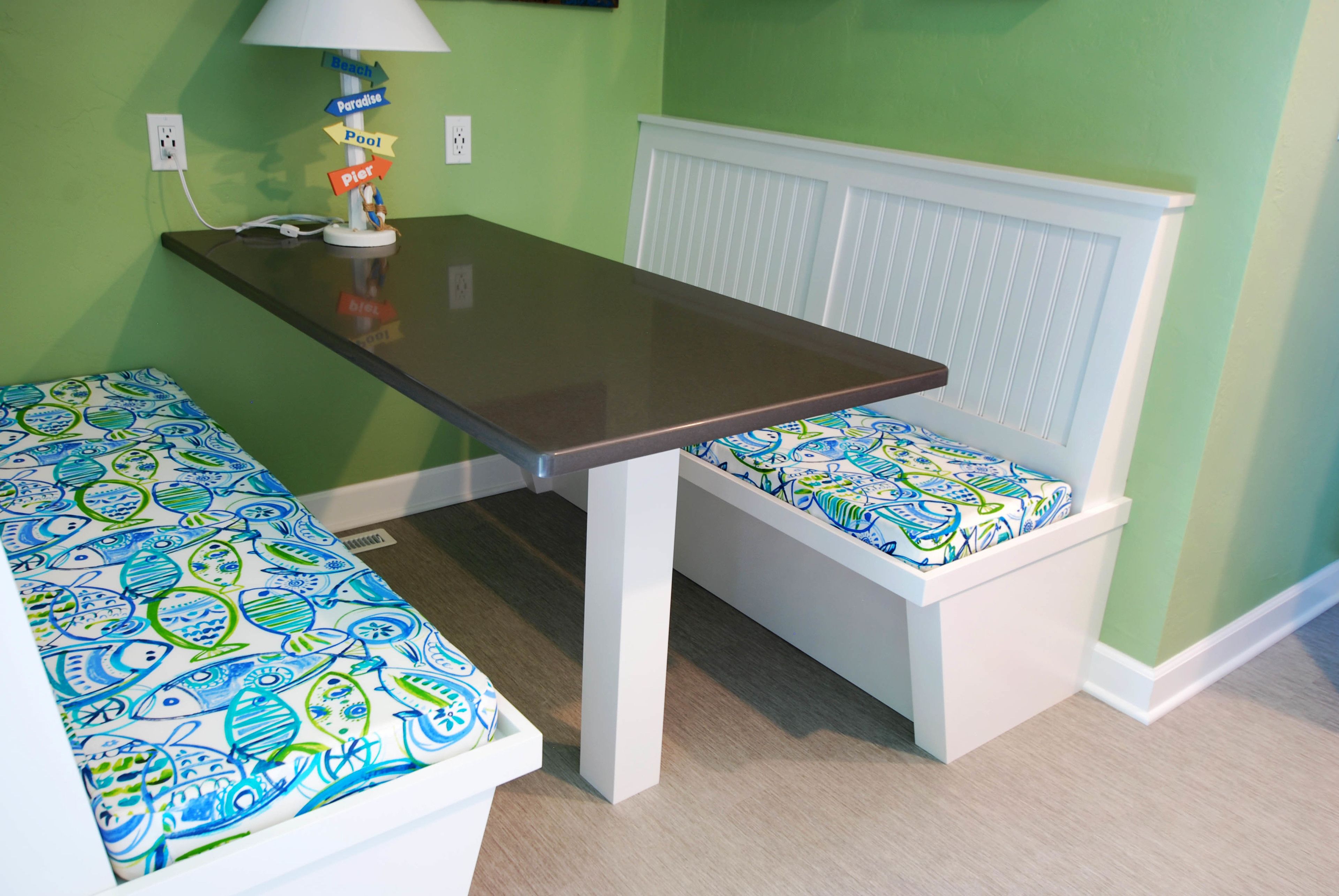 A room with a small table and bench, both with patterned cushions.