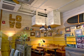 A cozy restaurant with wooden walls, a 'LOVE' sign, a chandelier, and a menu board.
