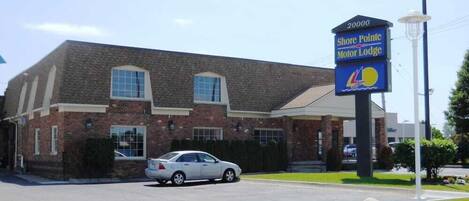 A two-story brick building with a sign for Shore Pointe Motor Lodge.