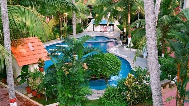 A pool area with palm trees and a small building labeled 'Sun Club'. - Country Spa Wellness Beach Resort (Thiruvananthapuram)