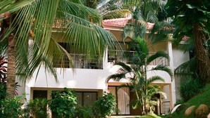 A two-story building with a balcony, surrounded by lush greenery and palm trees. - Country Spa Wellness Beach Resort (Thiruvananthapuram)