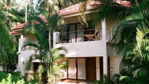 A two-story building with a balcony, surrounded by lush greenery and palm trees. - Country Spa Wellness Beach Resort (Thiruvananthapuram)