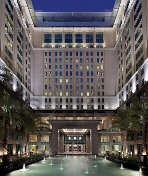 A modern hotel with a central courtyard, multiple floors, and a well-lit entrance. - The Ritz-Carlton Executive Residences (Dubai)