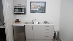 Eine kleine Küche mit Mikrowelle, Spüle und kleinem Kühlschrank.