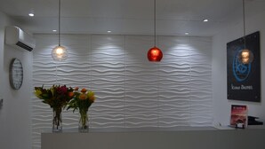 A reception area with a wavy wall design, a clock, and a poster.