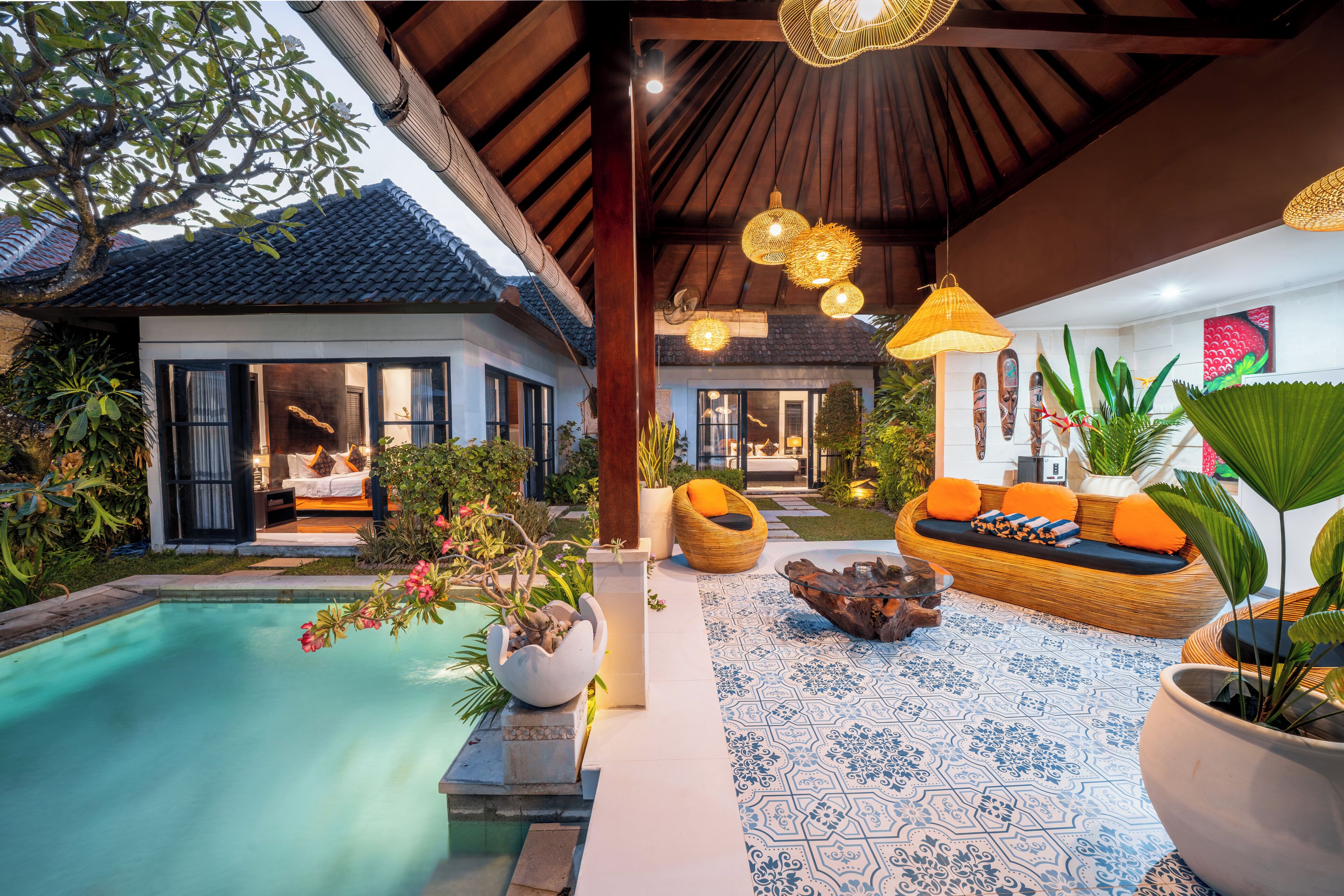 A poolside area with a lounge chair, a wooden bench, and a dining table.