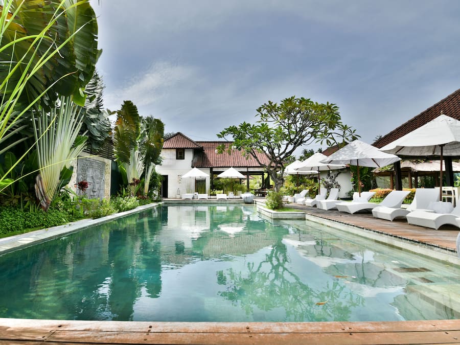 Una piscina al aire libre, sombrillas, tumbonas