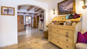 A cozy interior with a wooden dresser, a framed photograph, and a small table with decorative items. - Hotel Garni Lavendel (Lech am Arlberg)