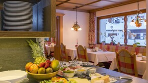 A dining area with a buffet setup, including a variety of fruits, cheeses, and meats. - Hotel Garni Lavendel (Lech am Arlberg)