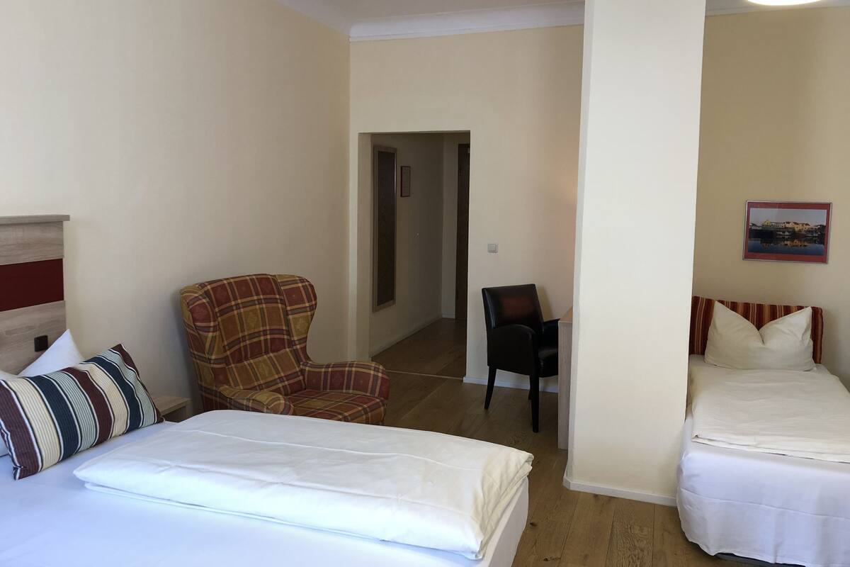 Ein Hotelzimmer mit Bett, Stuhl und kleinem Schreibtisch.