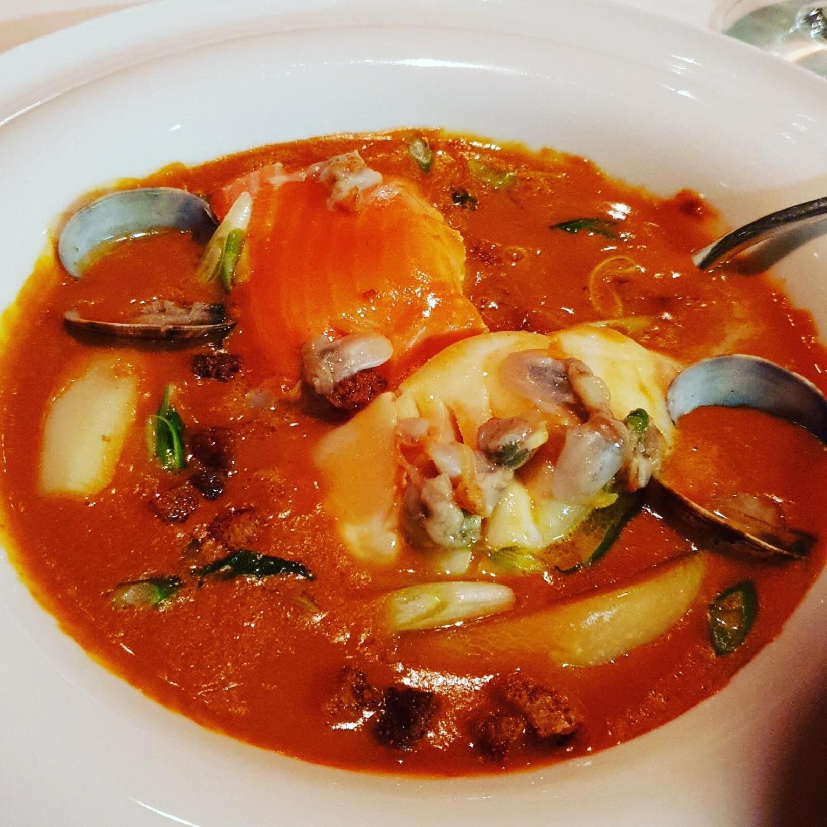 Un bol de ragoût de fruits de mer aux palourdes et aux pommes de terre.